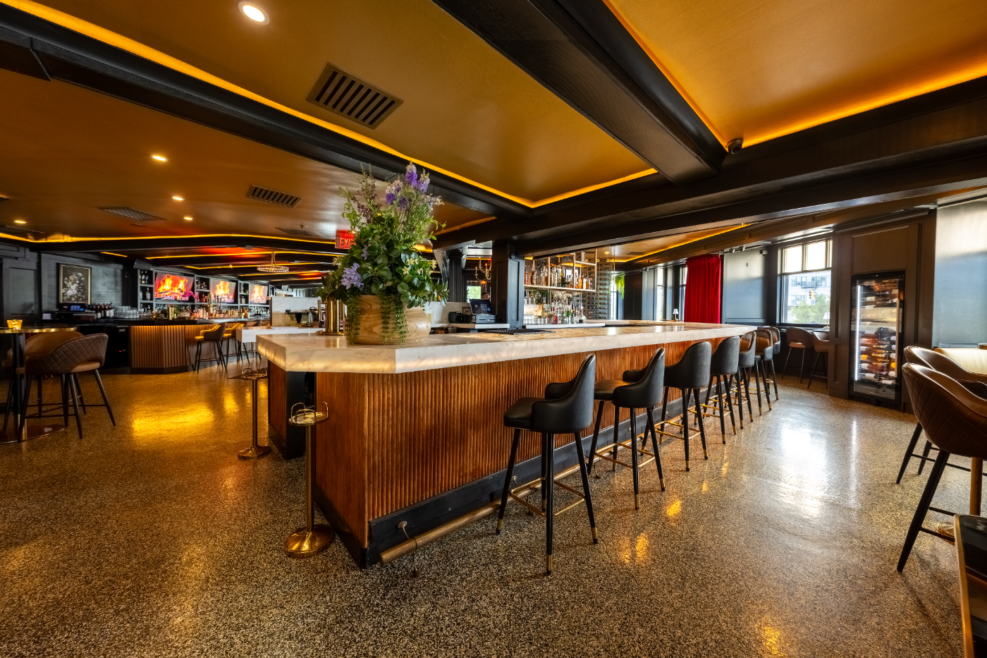 The wood-paneled bar island under glowing amber light