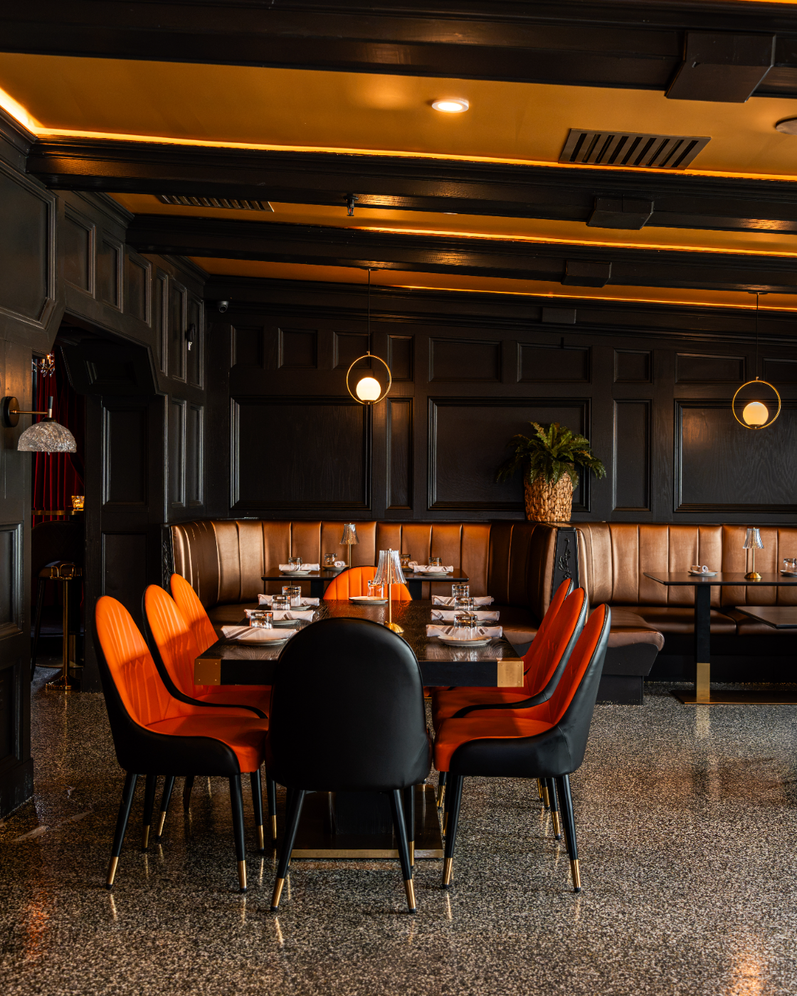 Moody dining corner with cognac leather chairs and table lamps