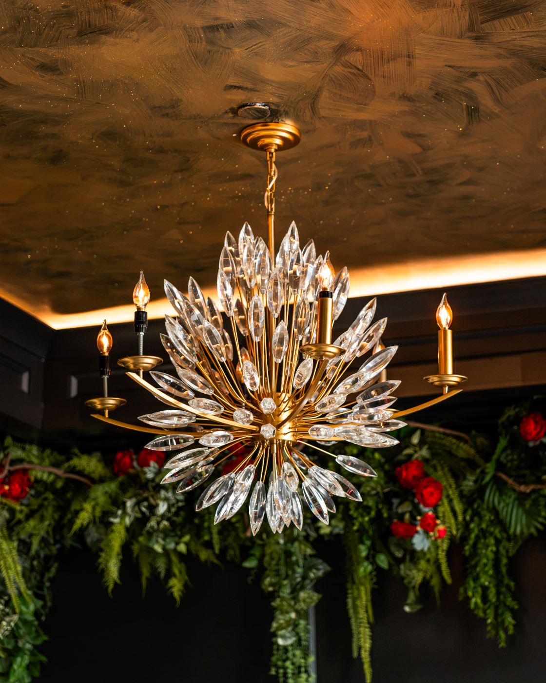 Crystal chandelier framed by holiday garland