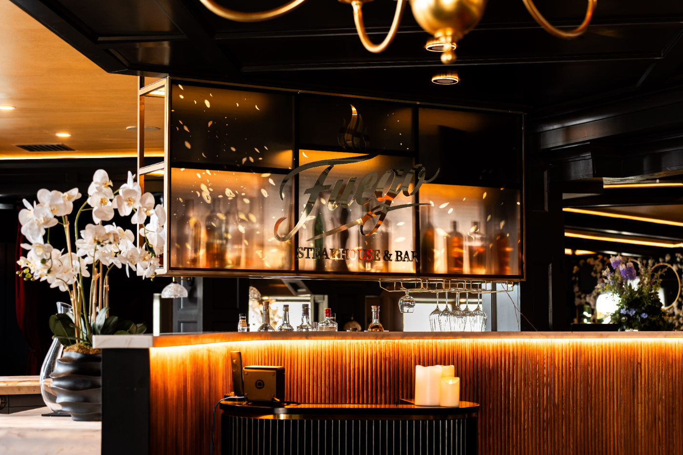 The back bar aglow with orchids and warm light