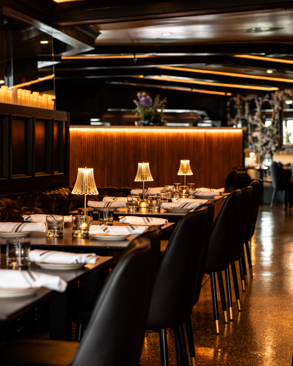 White-linen tables set in the dim glow of the dining room