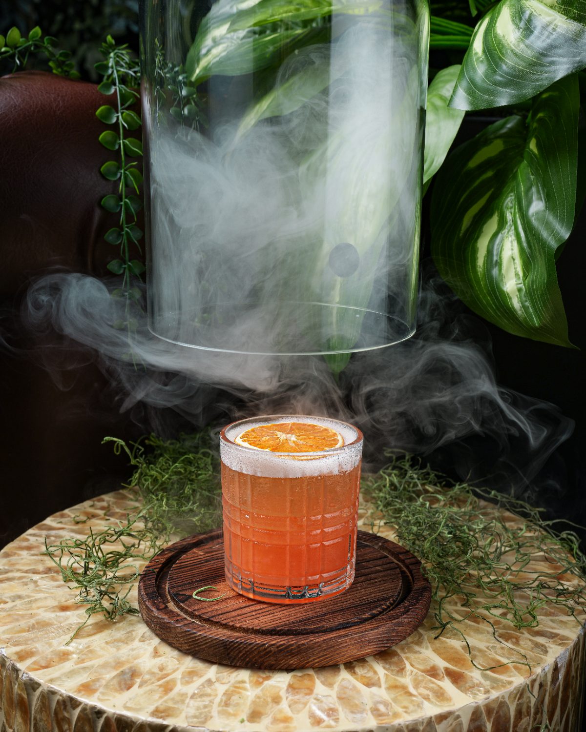 Smoked citrus cocktail served under a glass cloche