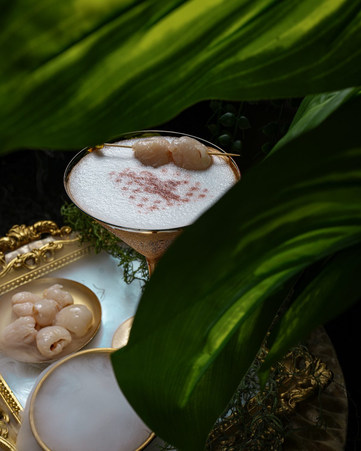Lychee martini with a silken foam top in a gold coupe